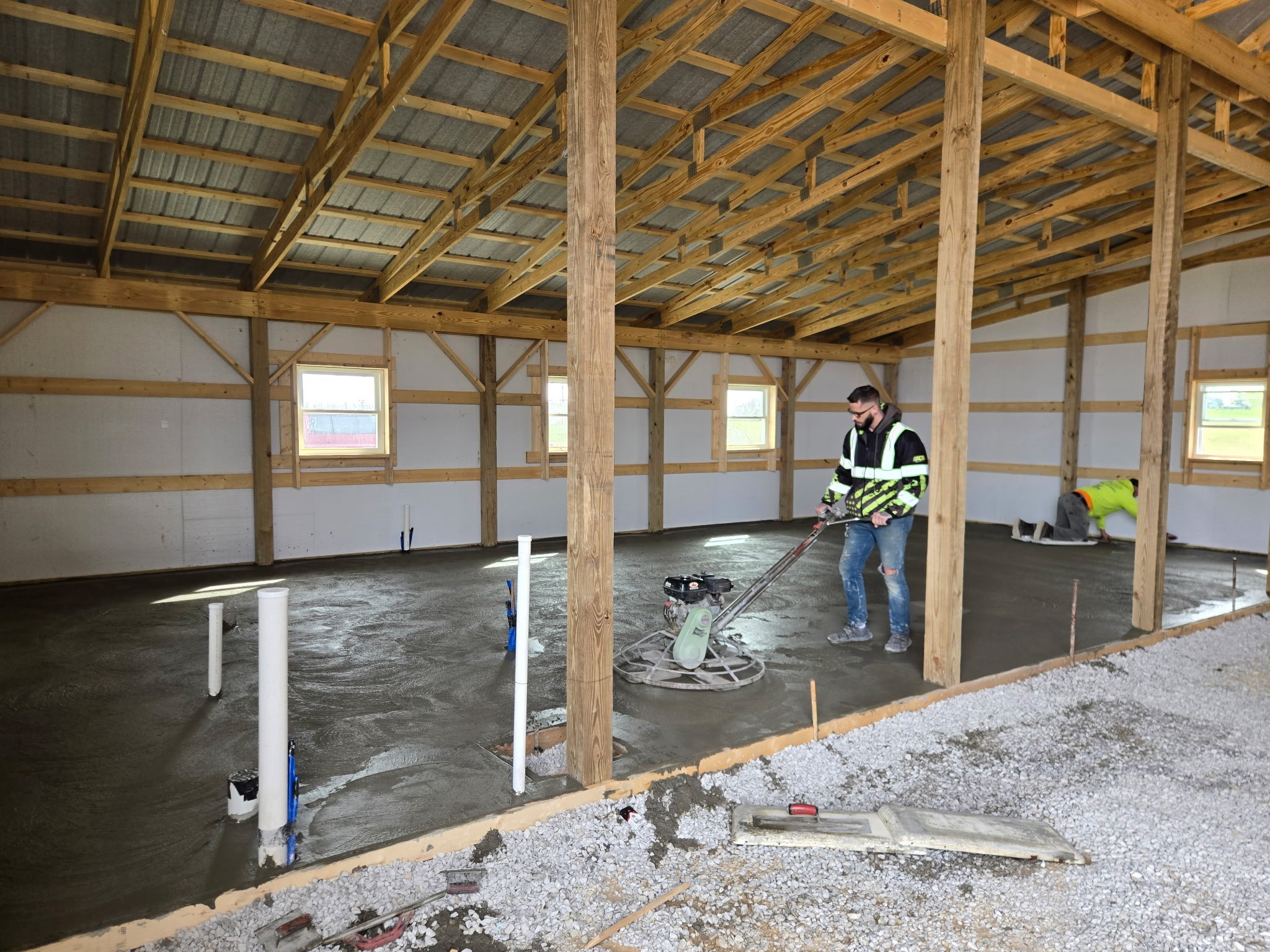 Finished concrete slab flooring inside a newly framed pole barn