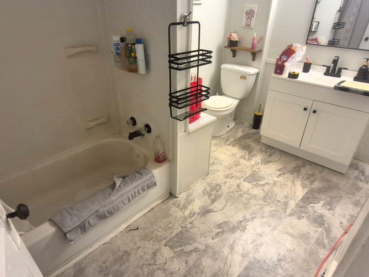 Before: dated bathroom with old flooring and fixtures